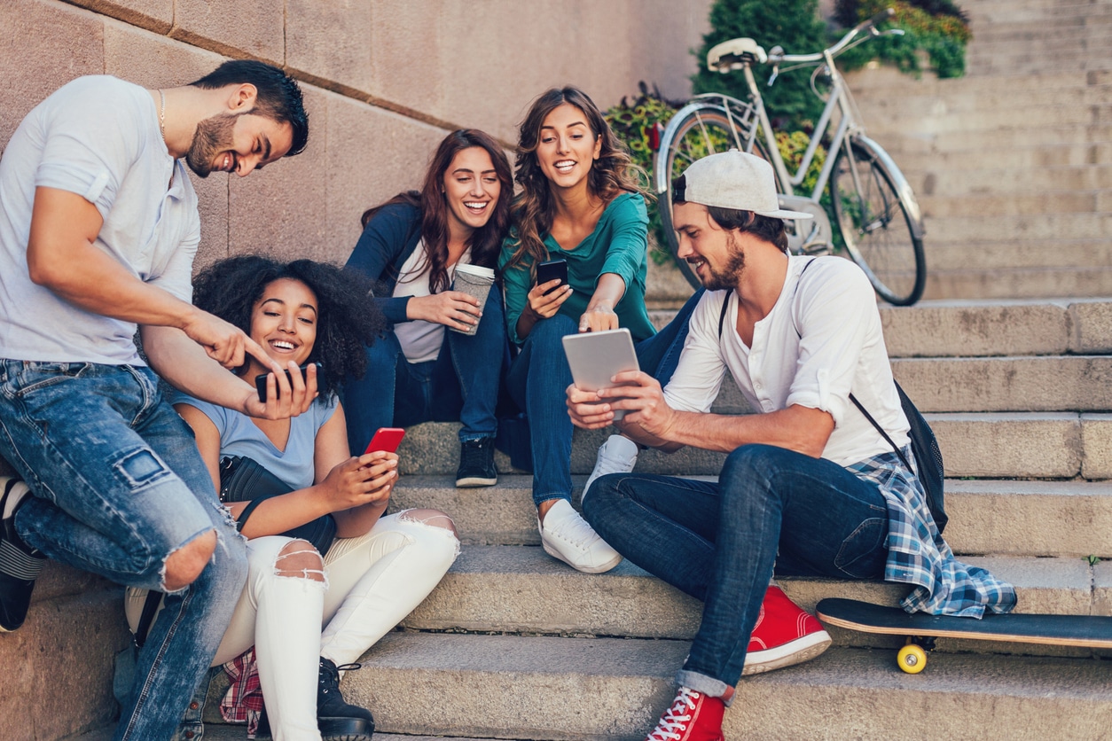 Young people sittings on steps with their mobile phones