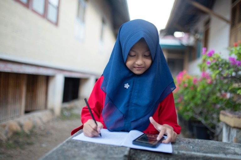 A girl using a mobile phone to help with homework